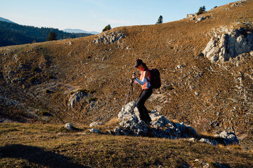 A female mountaineer, equipped with professional gear, enjoys the thrill of her climb as she...