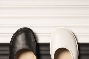 Shoes in white and black on a decorative relief panel with copy space.