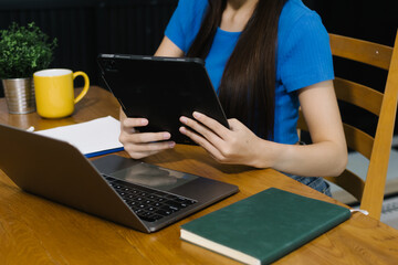 Woman using digital tablet at home, enjoying remote work or online entertainment. Cozy lifestyle,...