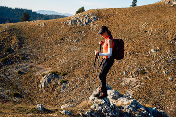A female mountaineer, equipped with professional gear, enjoys the thrill of her climb as she...
