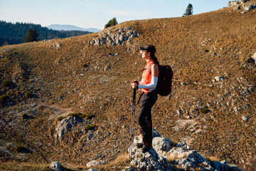 A female mountaineer, equipped with professional gear, enjoys the thrill of her climb as she...