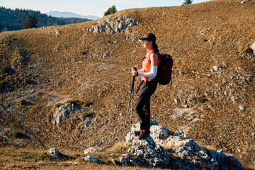 A female mountaineer, equipped with professional gear, enjoys the thrill of her climb as she...