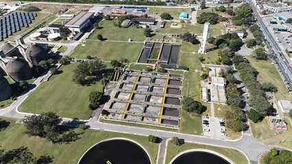 Visão aérea de estação de saneamento com tanques de lodo ativado, mostrando o processo...