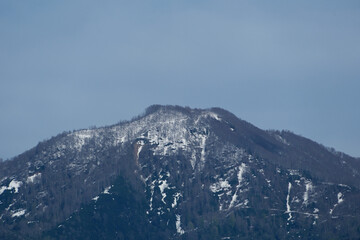 Mountain peak covered with snow on a background of blue sky.