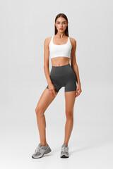 Fitness woman. Athletic girl on the gray background