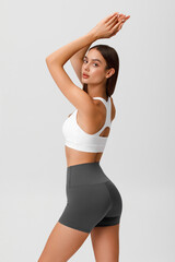 Fitness woman. Athletic girl on the gray background