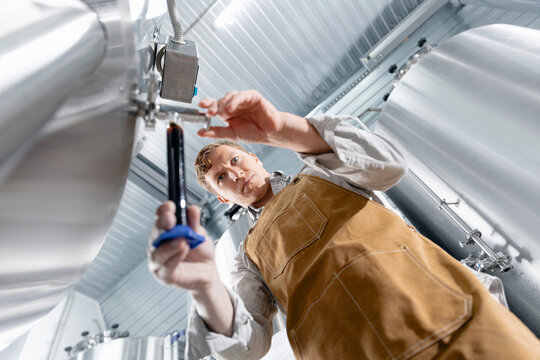 Quality control concept, brewer testing beer in modern brewery facility - Powered by Adobe