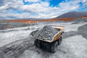 Excavator Loading coal into body big yellow quarry dump truck. Industry mining, production open pit...