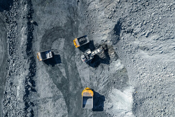 Open pit mine industry, big yellow mining truck for coal, top view aerial.