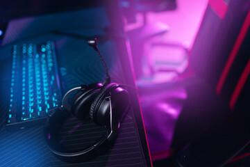Professional headphones with microphone for video games and cyber sports gaming monitor in neon...