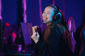 Winner happy Young caucasian female cyber sports streamer smiling with headset in gaming setup