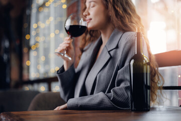 Young hispanic female sommelier enjoying wine tasting in elegant setting
