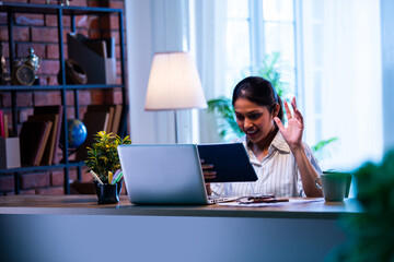 Indian employee working on tablet at office desk, using touch screen for business task