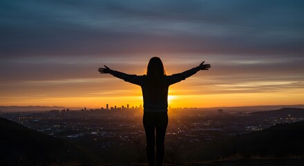 Fototapeta premium Person silhouette with outstretched arms at vibrant sunset over urban skyline.