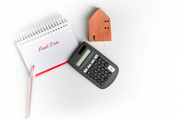 Past due on home mortgage concept with wooden house, calculator, pen, and red, text on notebook...