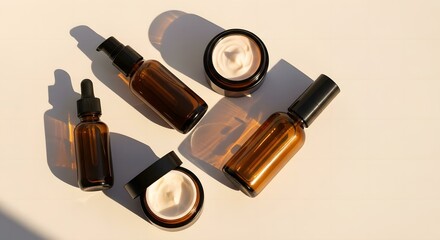 Obraz premium Brown glass containers filled with creams and oils cast soft shadows in golden sunlight.
