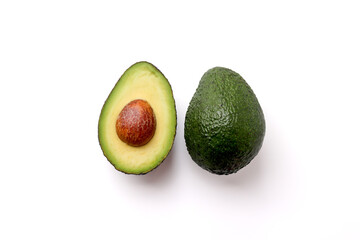 Avocado cut in half and a whole avocado on a white background