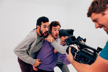 Three friends express excitement while being filmed