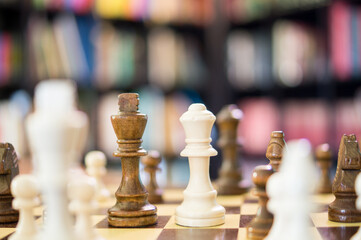 Chess game with selective focus of a black King and a white Queen amidst the pieces