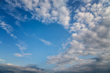 The sky with white cumulus clouds in a blue sky arching towards the horizon, a panoramic view of...