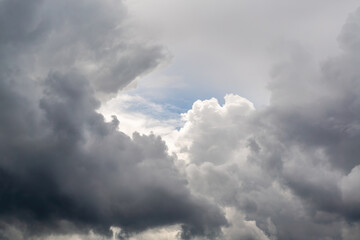 A glimpse of blue sky between gray clouds close-up, a gap in the clouds close-up, view among the...
