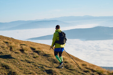 An extreme mountaineer, equipped with professional gear, pushes towards the peak of the mountain at...