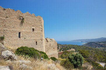 Historic Kritinia Castle on top of hill in Rhodes island, Greece. Idyllic countryside nature and Aegean sea seen from distance, blue sky. Castle of Kritinia also known as Kastello.