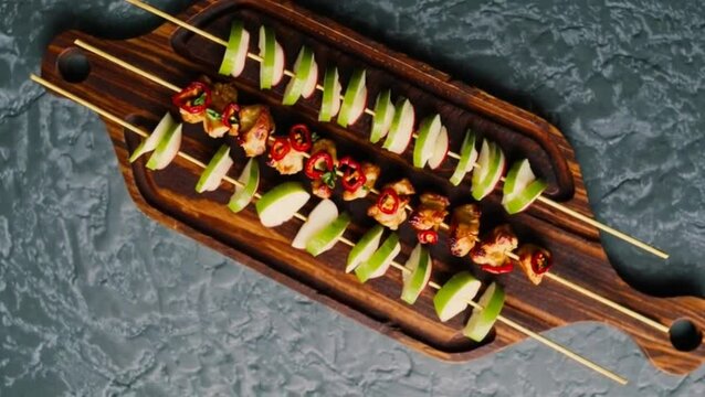 Chicken skewers with slices of apples and chili