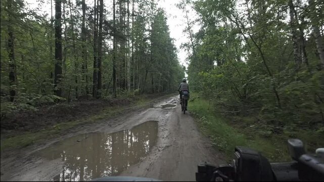 cycling in nature in wild places, bike-packing. Riding in the forest in the rain
