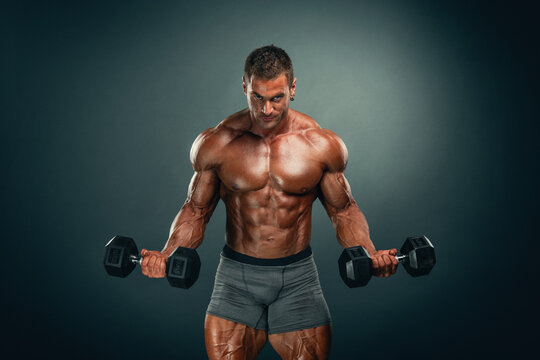 Muscular man lifting weights, performing bicep exercise with dumbbells