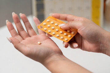 Birth Control Pills. A woman holding a contraceptive pill from a blister pack.