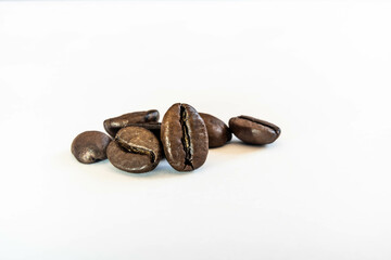 Isolated coffee beans on white background in clean studio lighting, macro composition showing rich brown texture, product photography concept