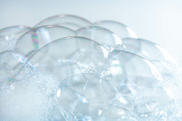 Close-up of transparent soap bubbles forming delicate dome shapes with soft lighting, ideal for...