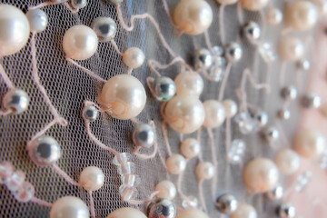 Detailed macro of mesh fabric with pearl and bead embellishments in elegant design pattern for fashion and apparel decoration