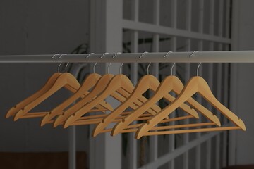 Empty clothes rack with wooden hangers in clothing store, 3D rendering.