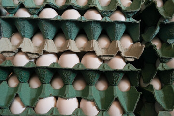 A frame full of chicken eggs in a cardboard box for sale at a market.