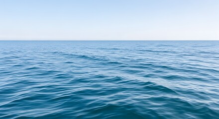 Obraz premium Calm Blue Ocean Water Ripples Under Pale Sky, Peaceful Seascape