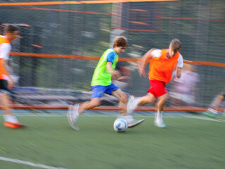  teens  boys plays football at a sports school .Blur.