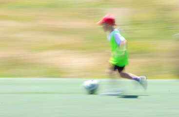 little  teen  boy  plays football at a sports school .Blur.