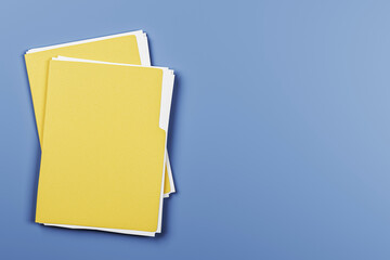Yellow document folders stacked on desk with copy space on blue background. Clean top view for office branding or business presentation template. 3D Rendering