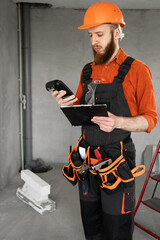 The cost of repair home. Bearded builder with clipboard and calculator at construction site....