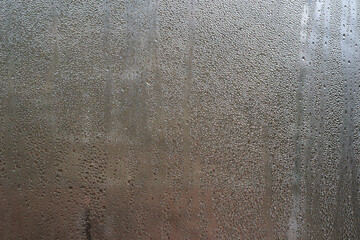pattern of condensation forms on a chilled glass surface, with water droplets. abstract blurred...