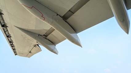 Close-up photo of an aircraft wing taken from below with the canoe fairing and slats