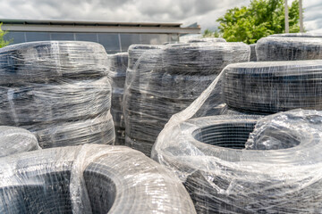 Coiled plastic pipes wrapped in stretch film for plumbing and irrigation supply.