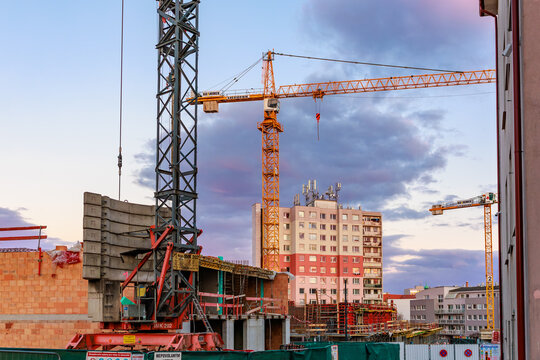 Urban construction site at sunset with cranes and buildings. March 17, 2025, Benesov, Czech Republic