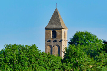 Steeple poking through the trees of the medieval Church of Plazac in the Perigord Noir, Dordogne,...