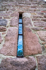 A very narrow window in the stone wall of the old castle