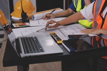 Closeup of team of industrial engineers meeting analyze machinery blueprints consult project on...