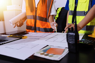 Closeup of team of industrial engineers meeting analyze machinery blueprints consult project on...