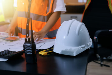 Closeup of team of industrial engineers meeting analyze machinery blueprints consult project on...